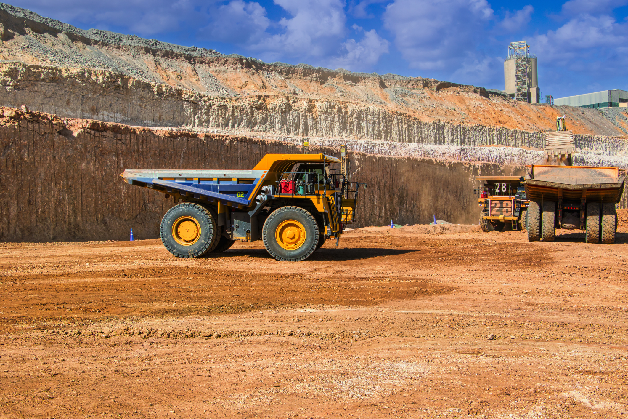 trucks getting loaded with kimberlite, excavator, open pit mine, large industrial operation to extract diamonds,
